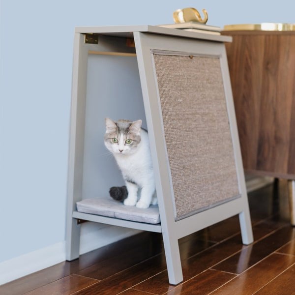 A wooden A-frame side table with a sheltered cat bed and an angled sisal scratching panel