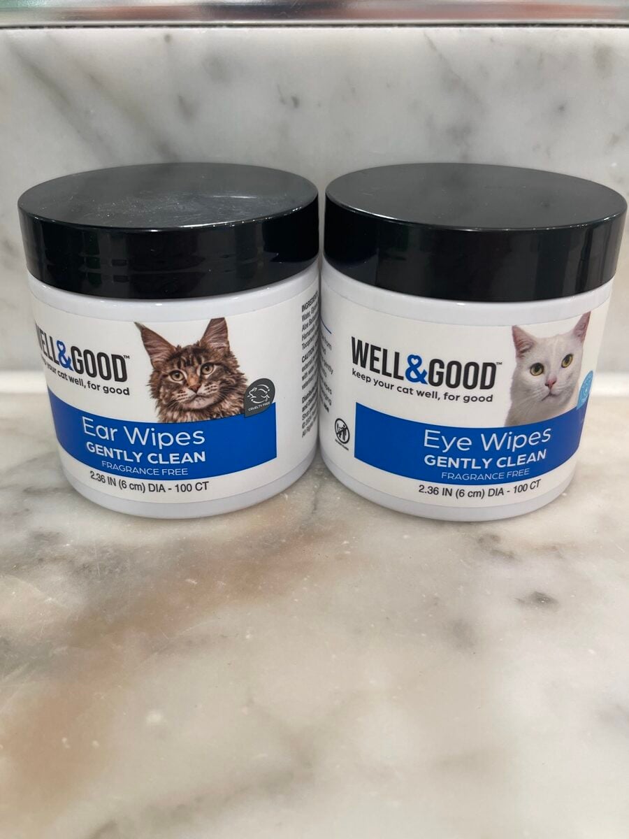 Two tubs of Well & Good cat wipes on a marble counter: ear wipes and eye wipes, both fragrance free