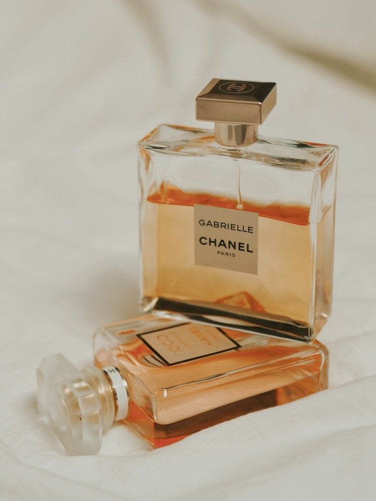 Two glass perfume bottles resting on pale fabric